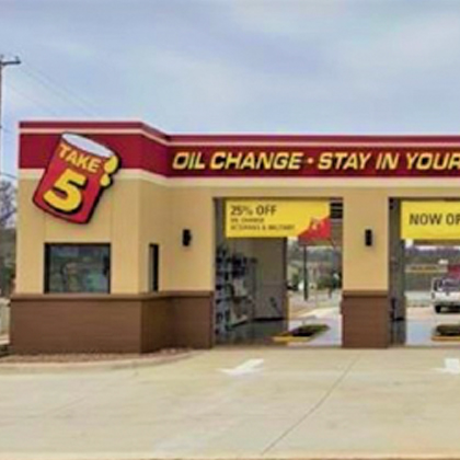 A Take 5 oil station with a sign that says oil change stay in your car, featuring modular construction.